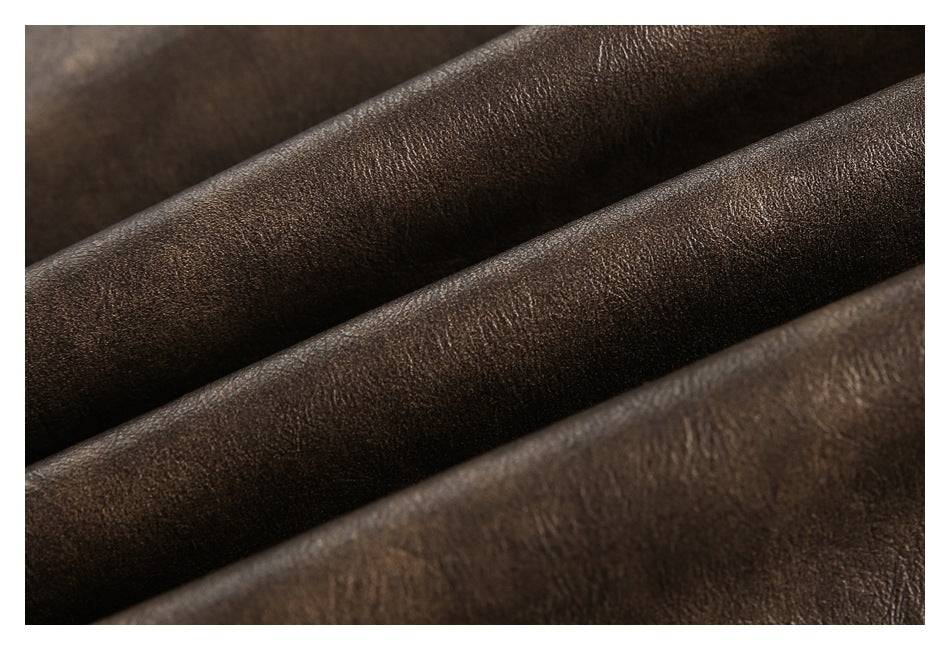 Extreme close-up of the textured dark brown jacket surface gathered into folds.