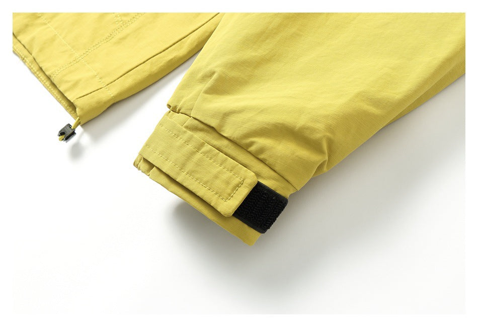Close-up of the mustard-yellow jacket sleeve cuff with a black hook-and-loop tab.