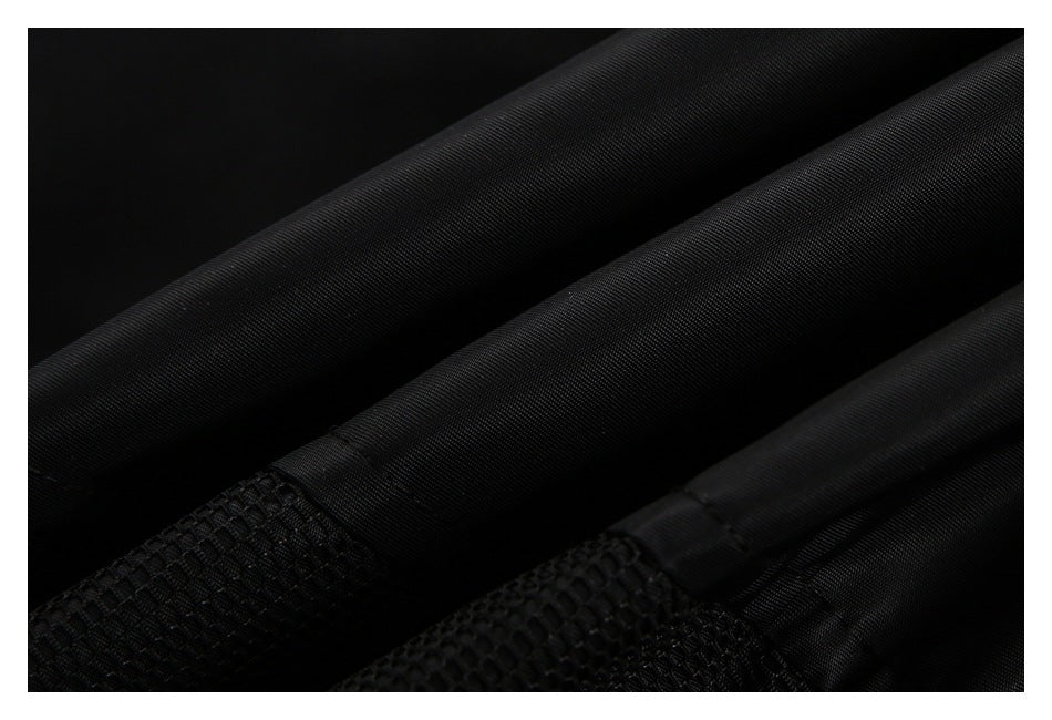 Close-up of black fabric panels with stitched seams and a textured mesh section.