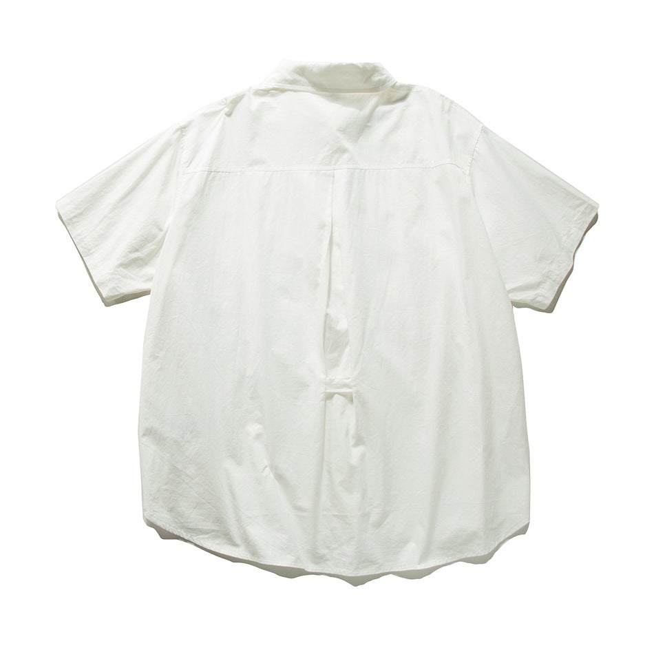 Back of the white short-sleeve shirt showing a back yoke, center box pleat and curved hem, laid flat
