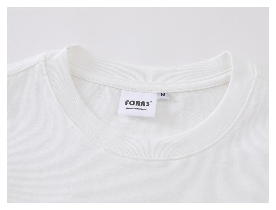 Close-up of the white shirt's ribbed crewneck and neck label, with an M size tag.