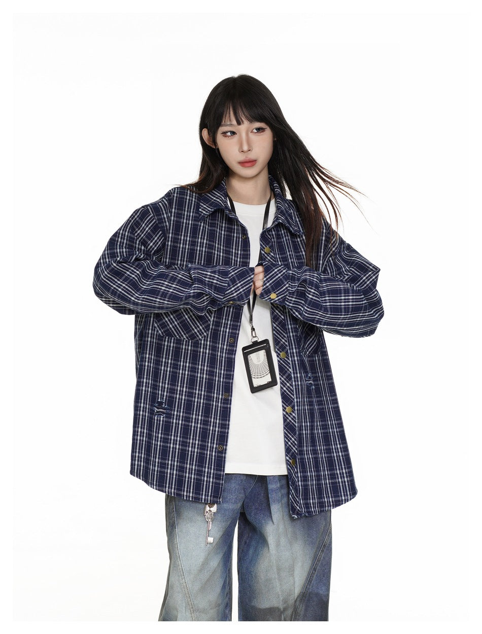 Model wearing an open navy plaid shirt over a white top, with a black lanyard and badge.