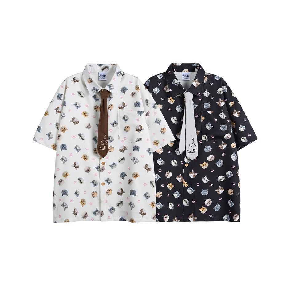 Two short-sleeve button-up shirts with cat and pink paw prints, shown in white and black colorways with contrasting ties.