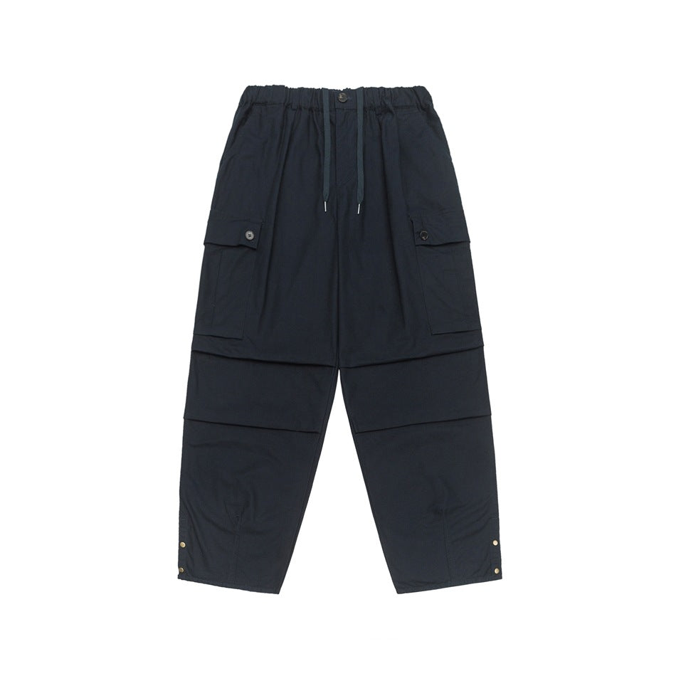 Navy wide-leg cargo pants with drawstring waist, thigh flap pockets and snap buttons at hems, flat front view