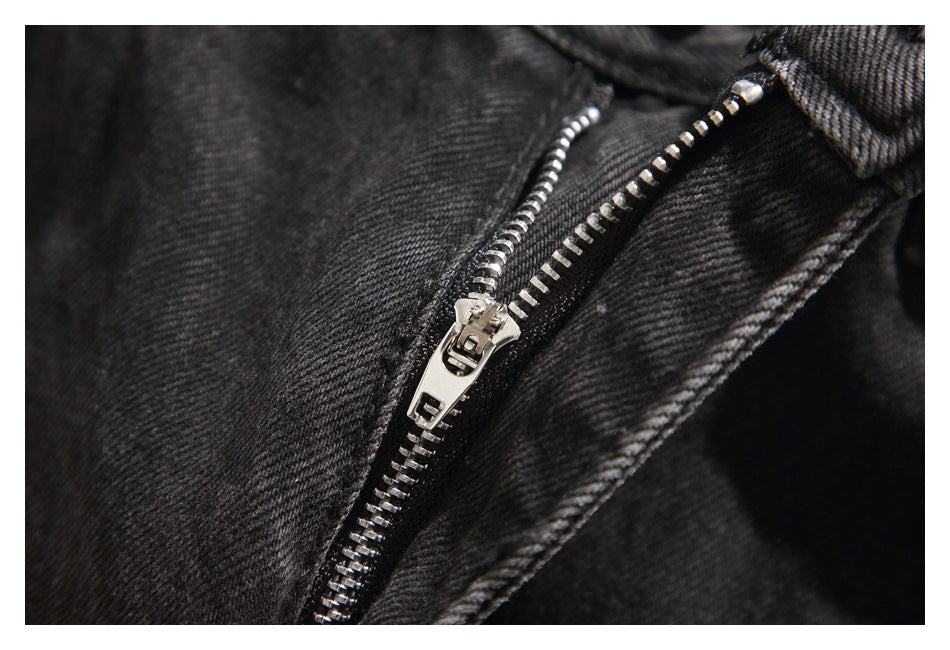 Close-up of a silver zipper on black denim.