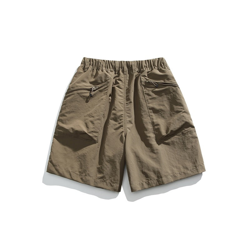 Taupe shorts laid flat, with an elastic waistband and two slanted zip pockets.