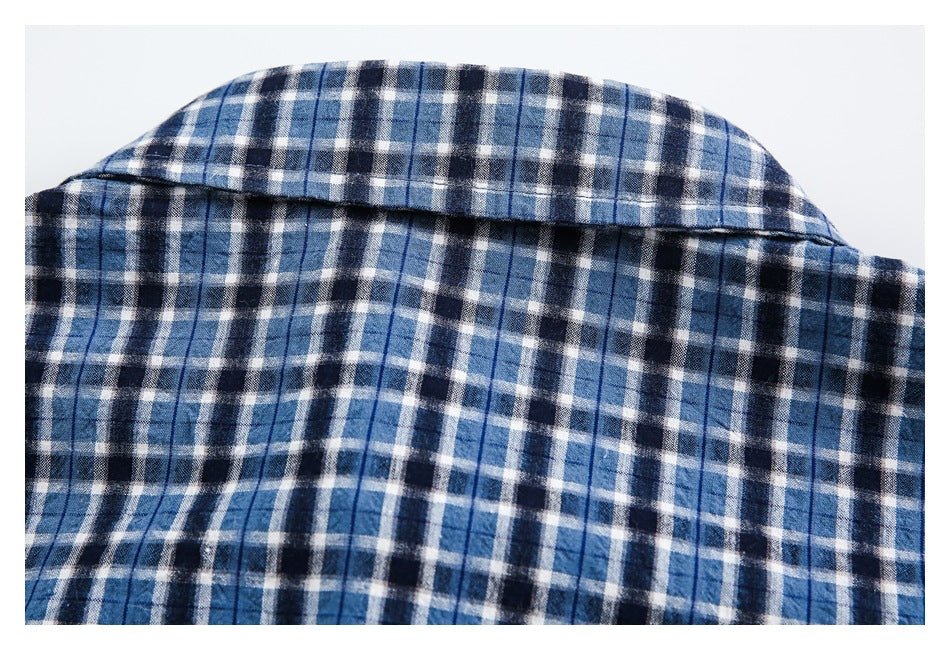 Close-up of the collar and upper back of a blue, navy and white plaid shirt.