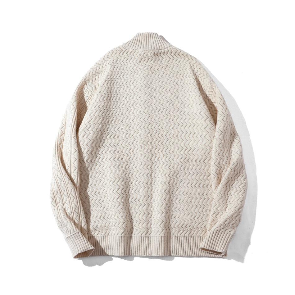 Back view of a cream knit sweater laid flat, with a ribbed stand collar, cuffs, and hem.