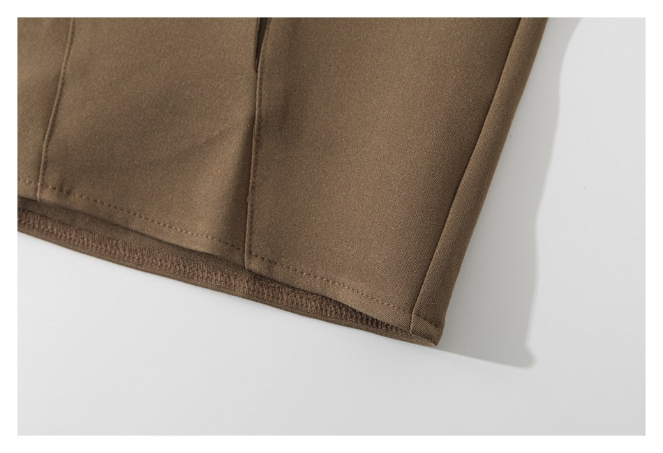 Close-up of the brown garment's stitched lower hem and finished edge.