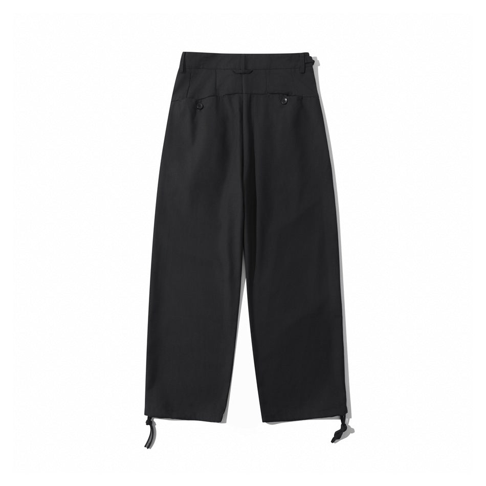 Back view of black wide-leg trousers with two button-detail back pockets and hem drawcord ties