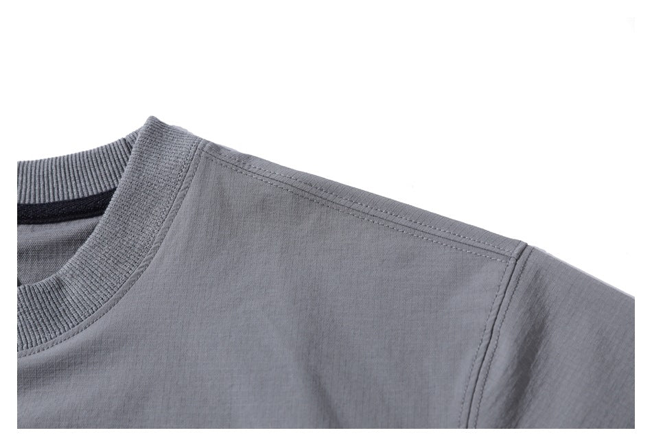 Close-up of a gray top’s ribbed crew neckline, shoulder seam, and upper sleeve.