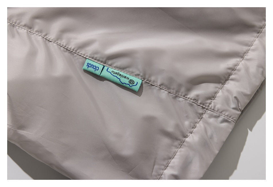 Close-up of a pale taupe garment seam with a turquoise woven label.