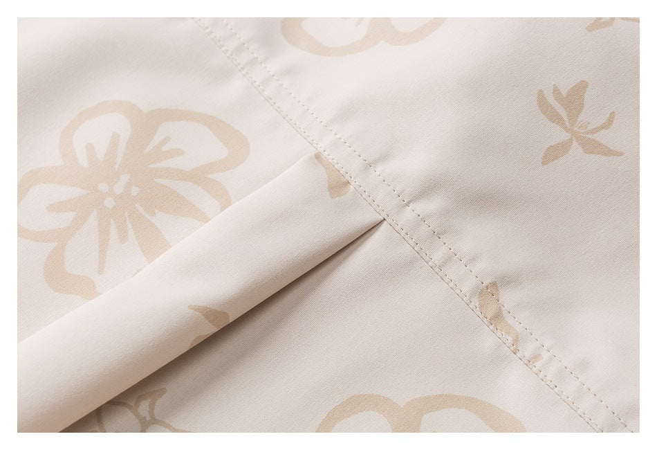 Close-up of cream fabric with a beige floral print and a neatly stitched seam.
