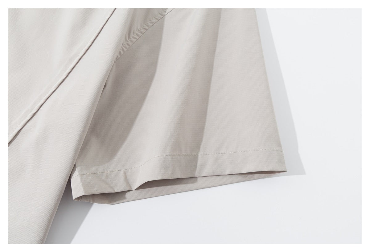 Close-up of a light beige garment hem with a folded edge and visible stitching.