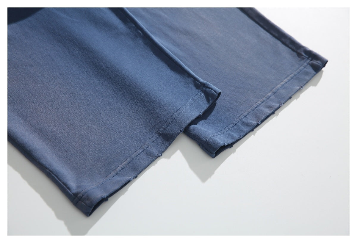 Close-up of the straight stitched hems on navy pant legs.