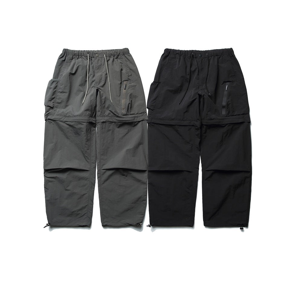 Front view of two pairs of cargo pants, one gray and one black, with elastic waists and paneled legs.