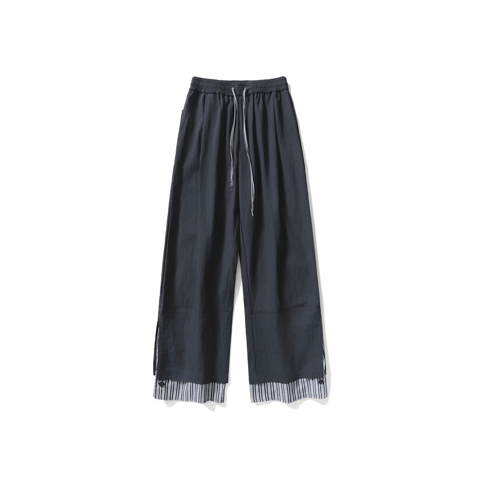 Black wide-leg drawstring pants with a striped layered hem, flat front view