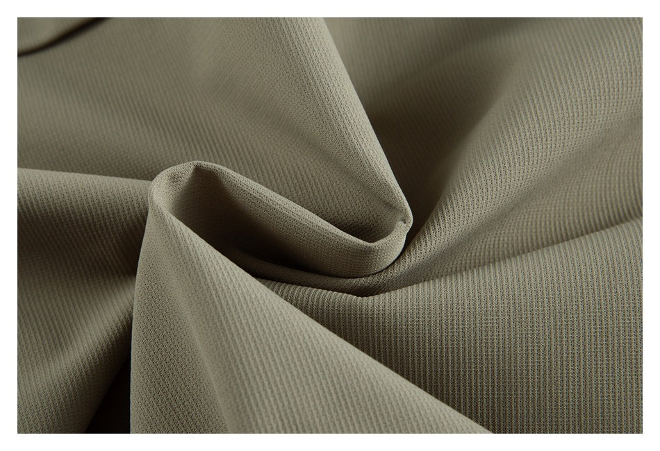 Macro view of the textured olive-gray jacket fabric folded into soft drapes.