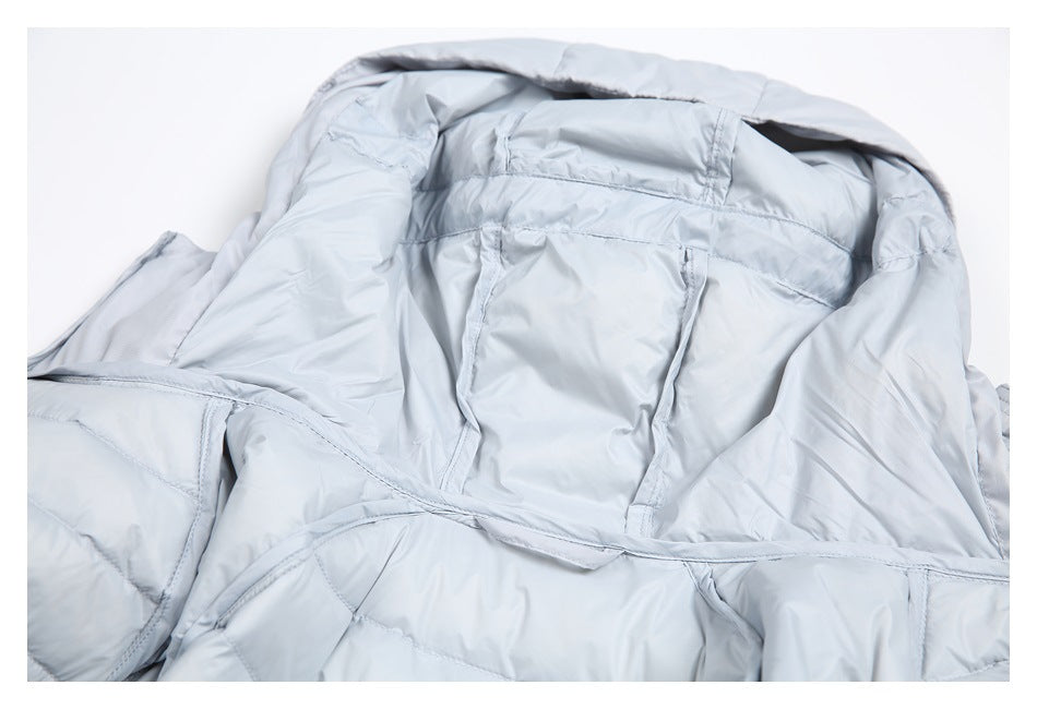 Close-up of the pale gray jacket interior, showing the hood, quilted lining, and a small pocket.