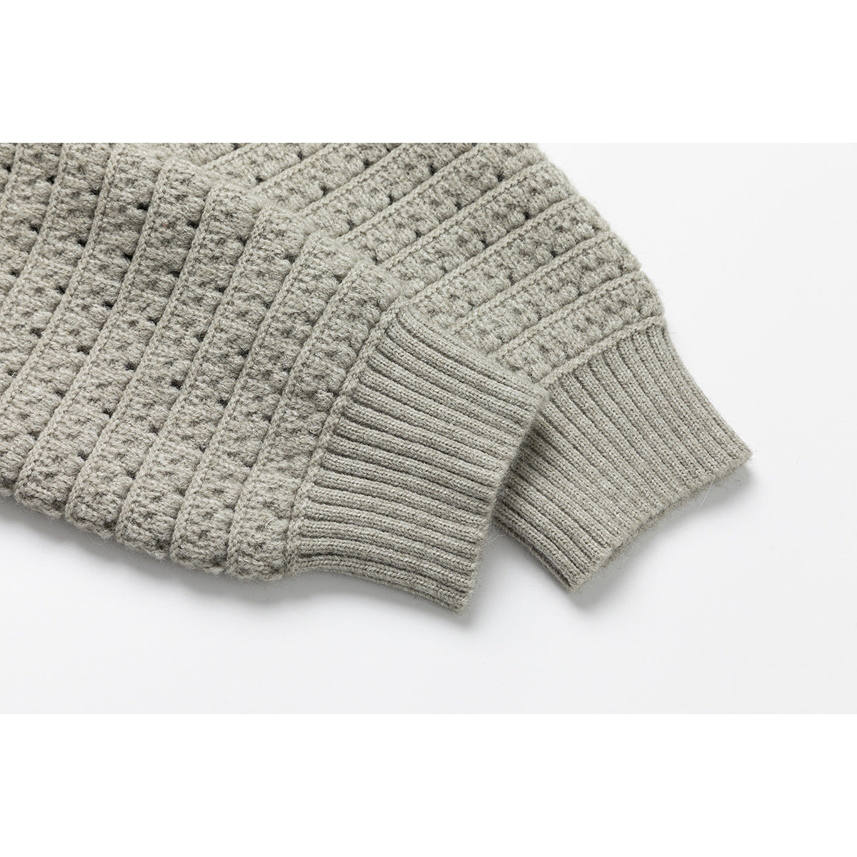 Close-up of the light gray cardigan's long sleeve cuff and textured knit pattern.