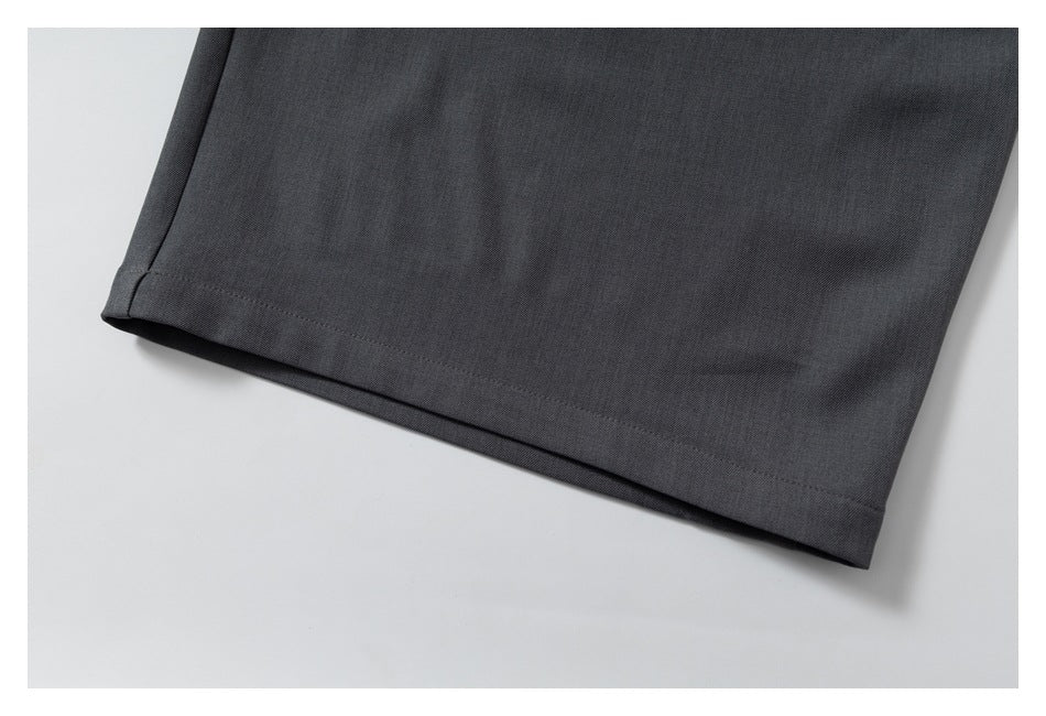 Close-up of the straight stitched hem on a dark charcoal trouser leg.