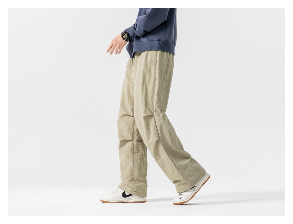 Side view of a model walking in khaki wide-leg pants with a blue sweatshirt and white sneakers