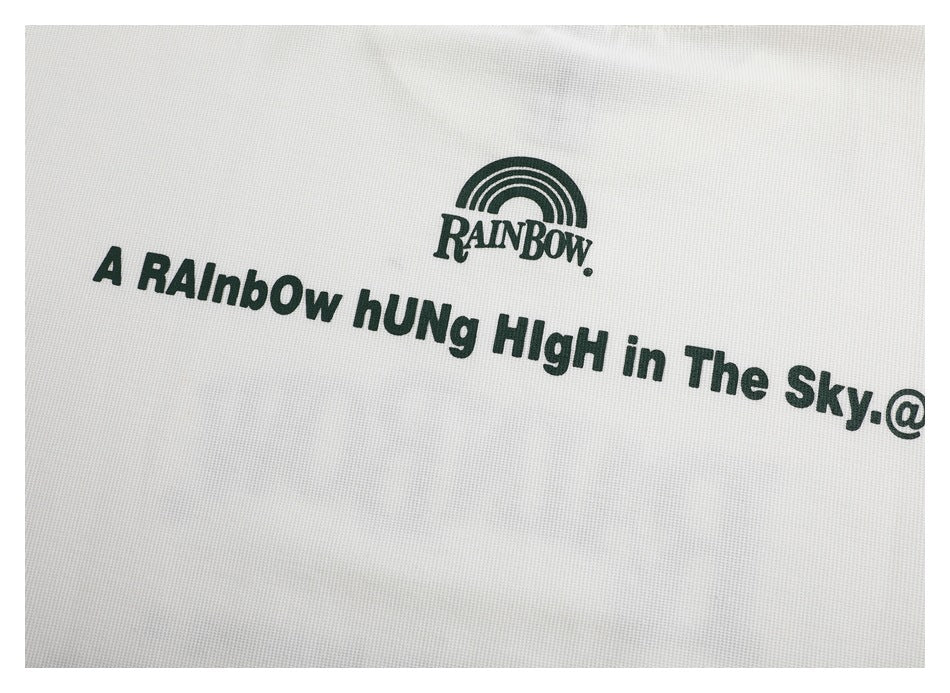 Close-up of a dark green rainbow logo and English lettering printed on white fabric.