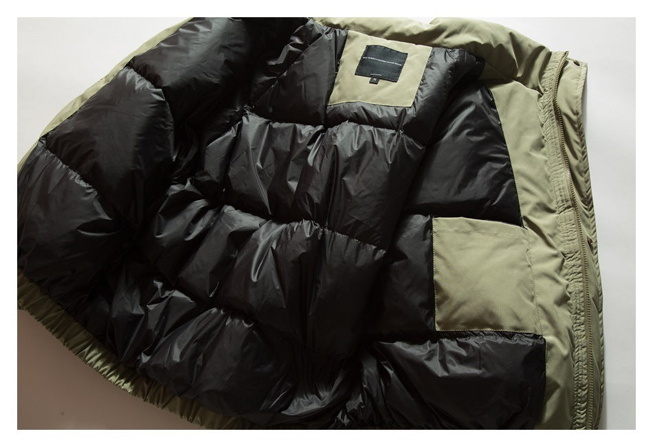 Close view inside an olive-green jacket, showing black quilted lining, an interior pocket and a small neck label.