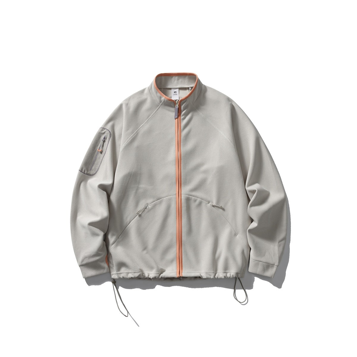 Light warm gray waffle-knit zip jacket with orange zipper trim, sleeve pocket and drawcord hem, flat view