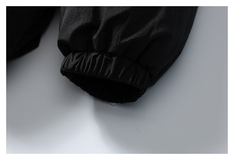 Close-up of a black jacket sleeve ending in a gathered elastic cuff.