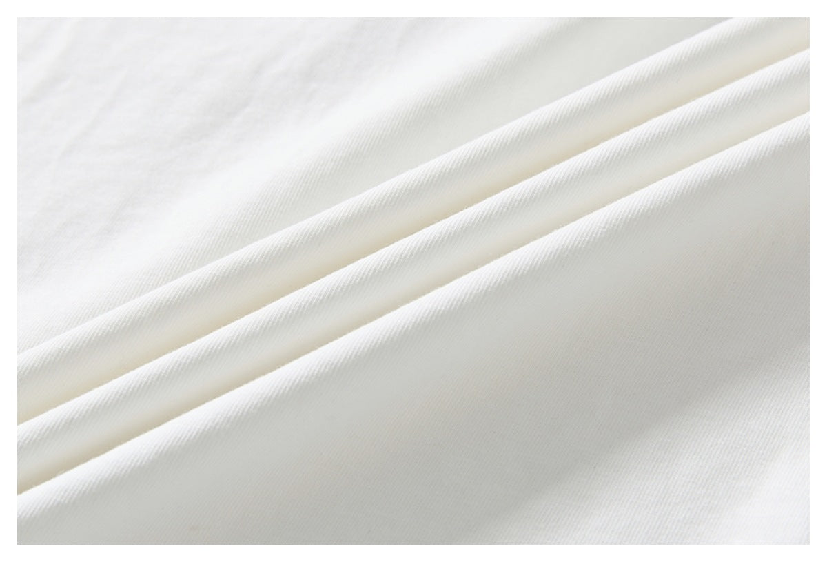 Close-up of softly folded white shirt fabric showing its surface and drape.