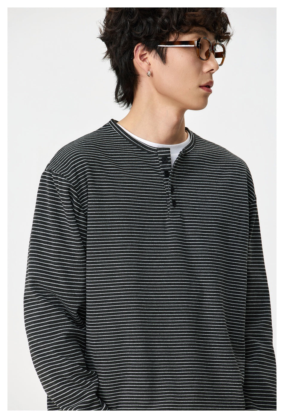 Close-up of a model wearing the gray striped henley top over a white tee, showing the button placket