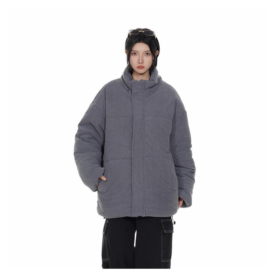 Front view of a model wearing a charcoal-gray padded jacket with a high collar and roomy front pockets.