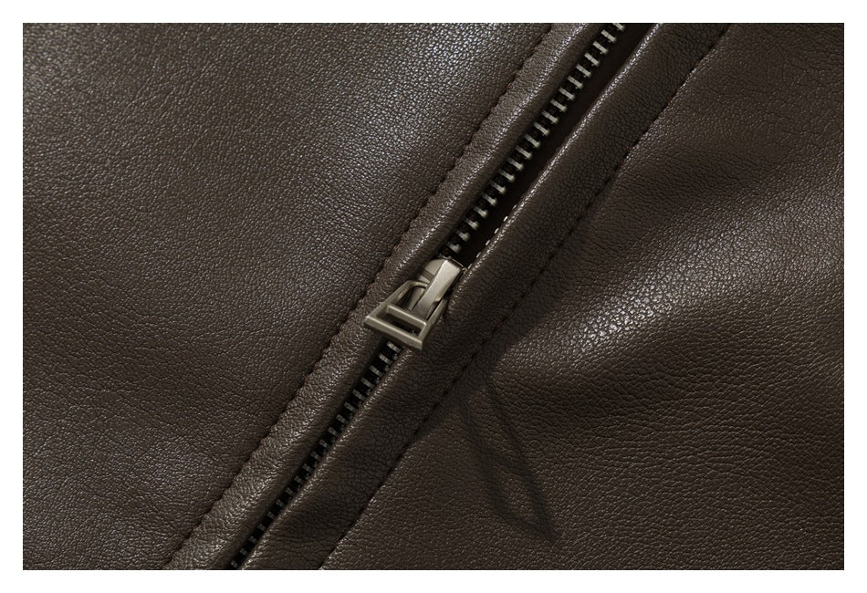 Close-up of the dark brown garment's metal zipper and textured surface.
