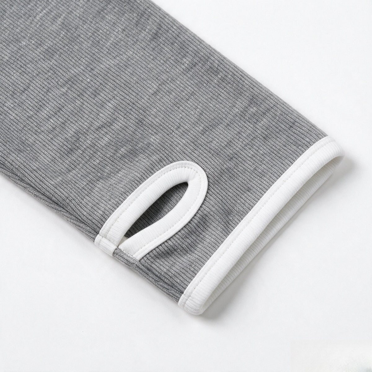 Close-up of a gray ribbed sleeve with white trim and a small loop detail near the cuff.