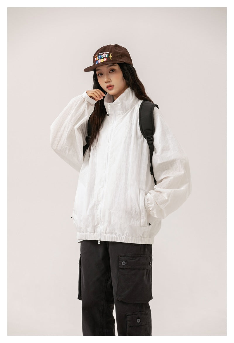 Model wearing a white zip-front jacket with a high collar, roomy sleeves and an elasticated hem.