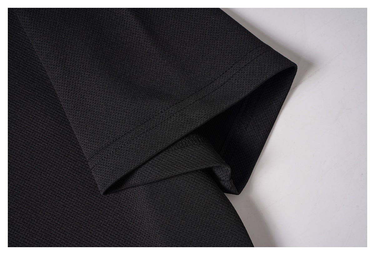 Close-up of the black shirt's short sleeve and stitched cuff hem.