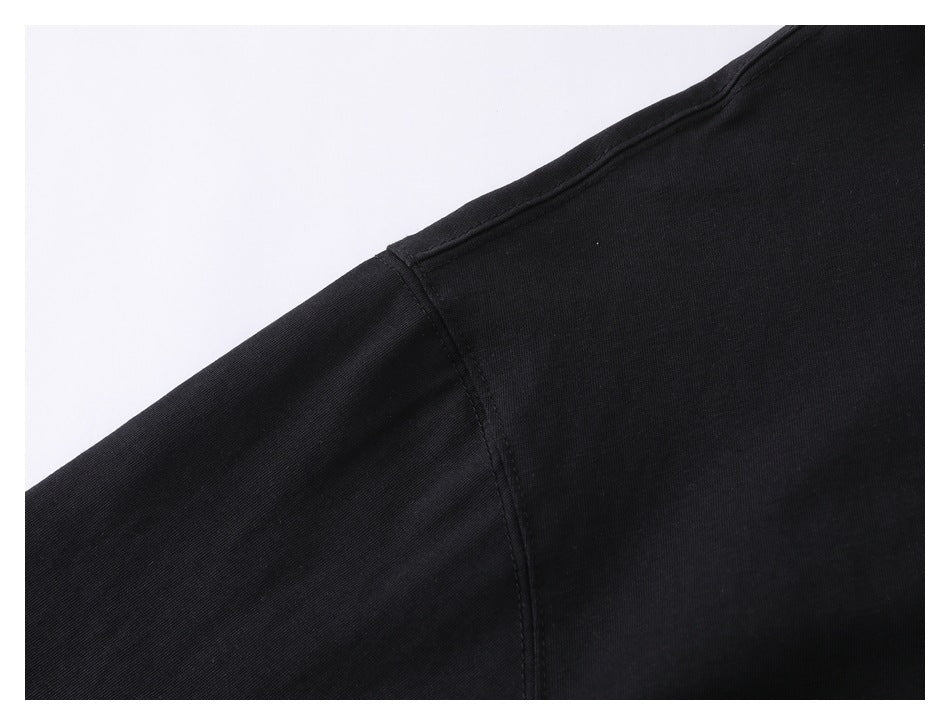 Close-up of the black top's shoulder seam and sleeve fabric.