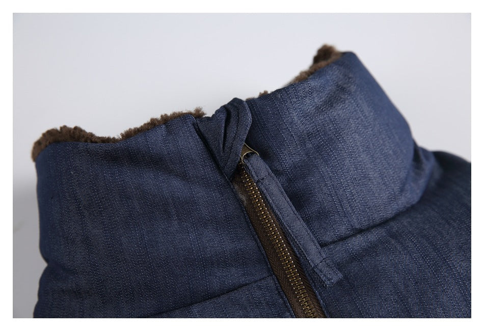 Close-up of a navy jacket's high collar, brown inner lining, and brown front zipper.