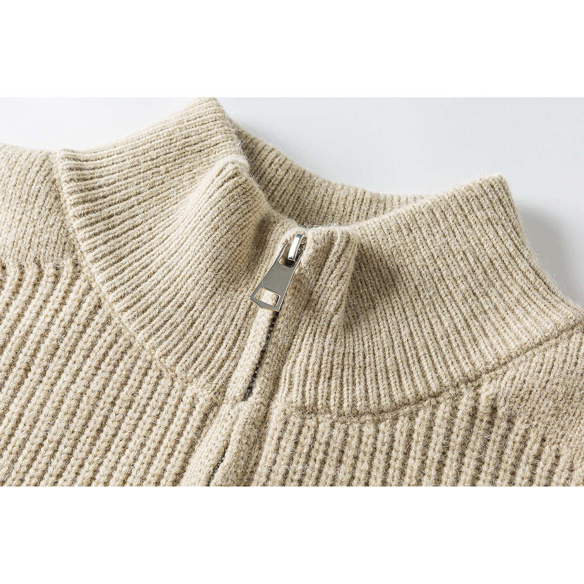 Close-up of a beige rib-knit sweater's stand collar and short zipper.