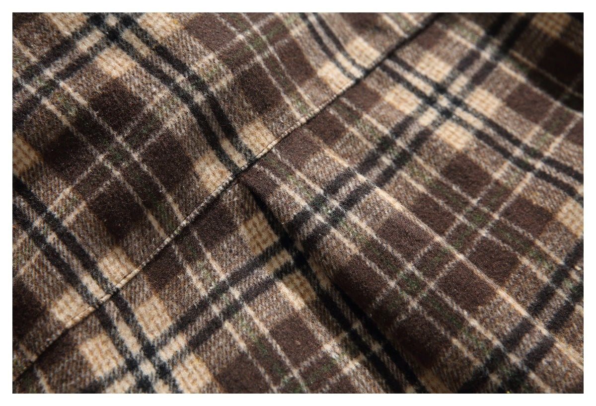 Close-up of a chest pocket and seam on the brown, tan and cream plaid shirt.