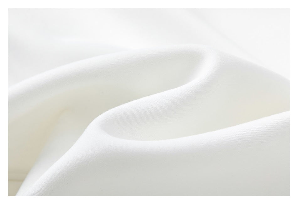 Macro view of the white sweatshirt fabric, showing its smooth surface and soft folds.