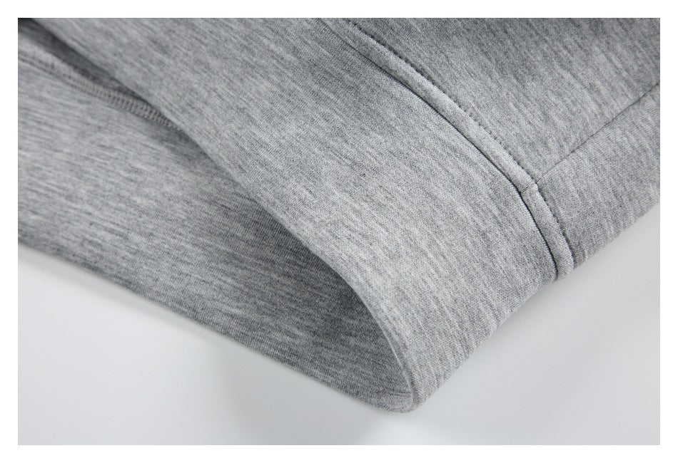 Close-up of the light gray jacket's curved seam and finished edge.