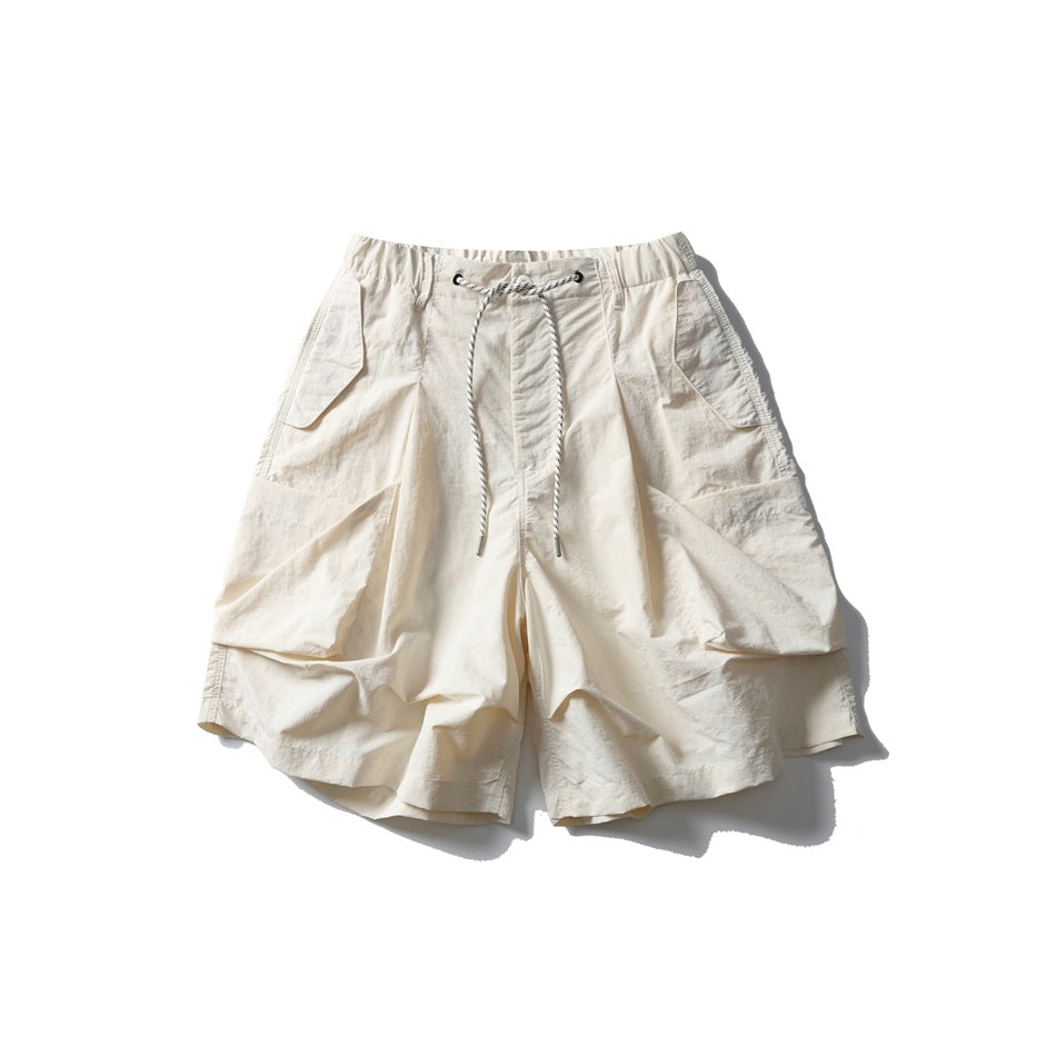 Off-white wide-leg shorts with large pleated pockets and a striped drawcord, flat lay