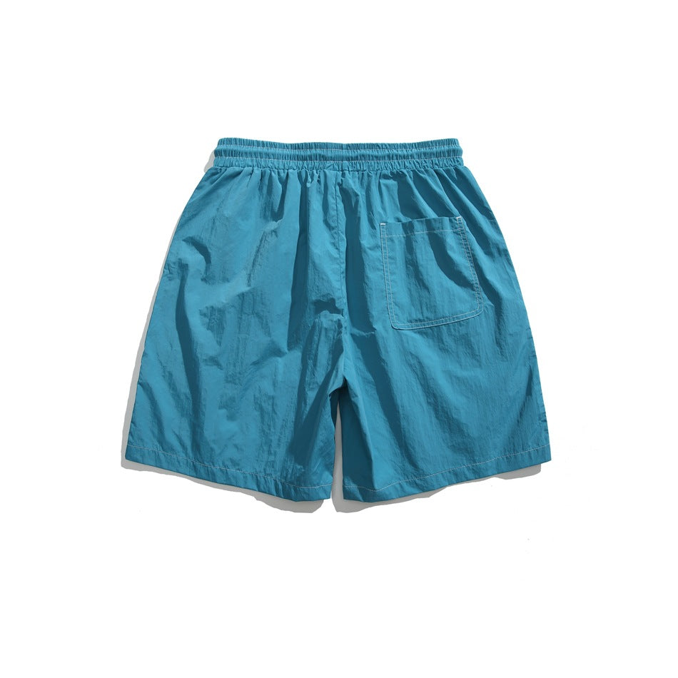 Back view of bright blue shorts with an elastic waistband and a single rear patch pocket.