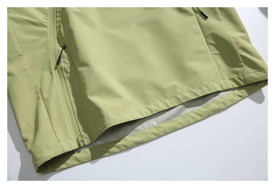 Close-up of the pale olive jacket's lower hem, seam, and zipper edge.