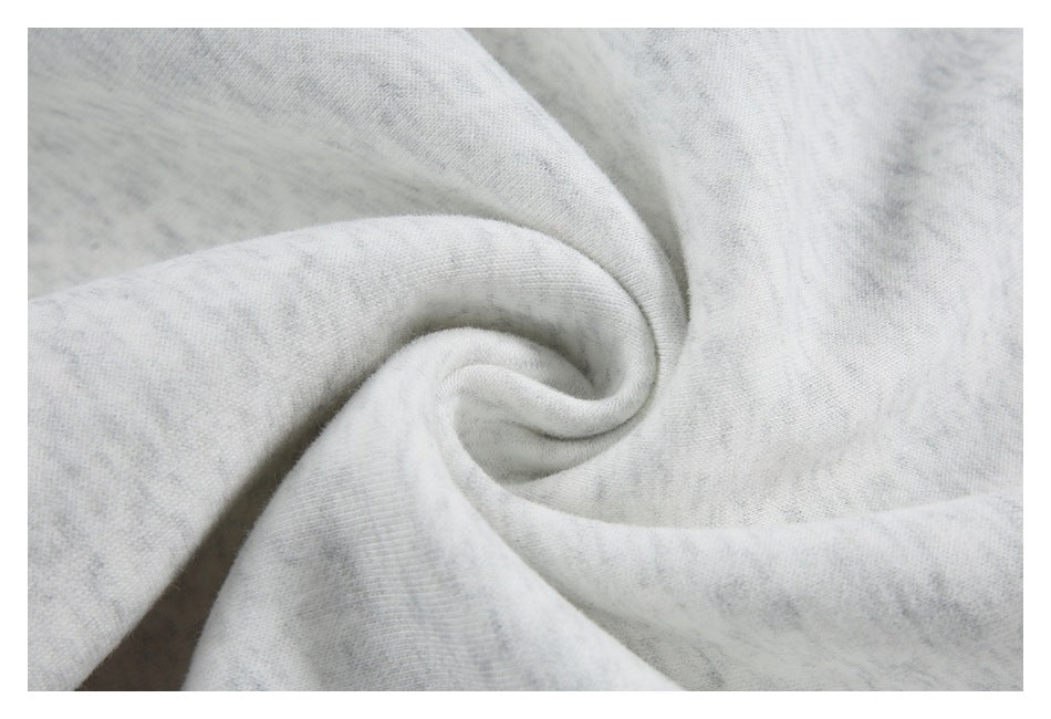 Close-up of light gray heather sweatshirt fabric gathered into a soft spiral fold.