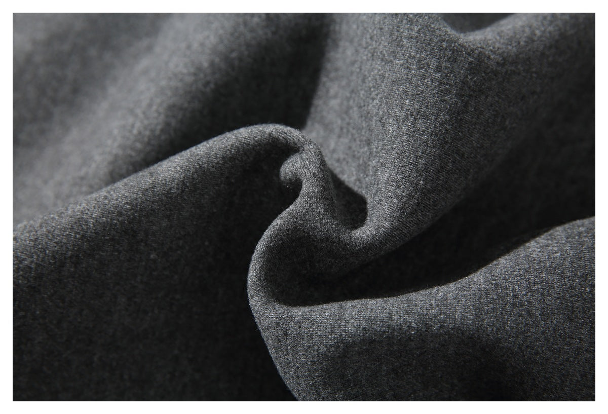 Macro view of charcoal gray pant fabric folded to show its surface texture.