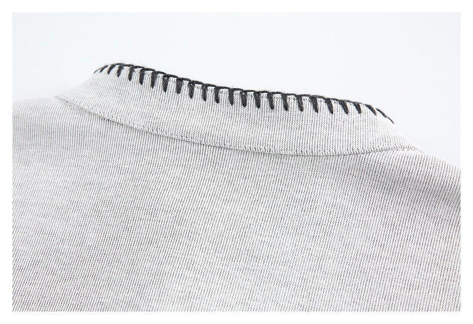 Close-up of a light gray garment collar with contrasting dark blanket stitching along the edge.