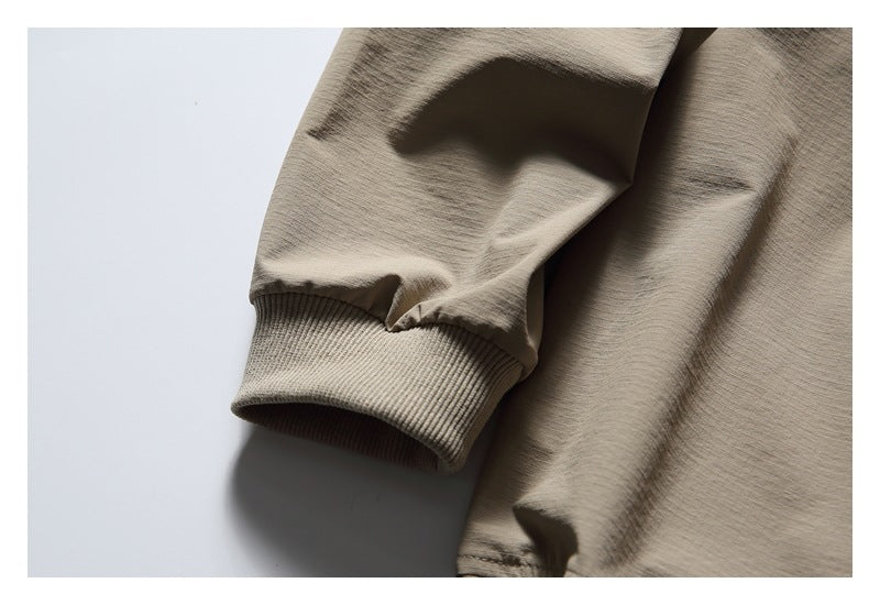 Close-up of the taupe pullover's long sleeve and ribbed cuff.